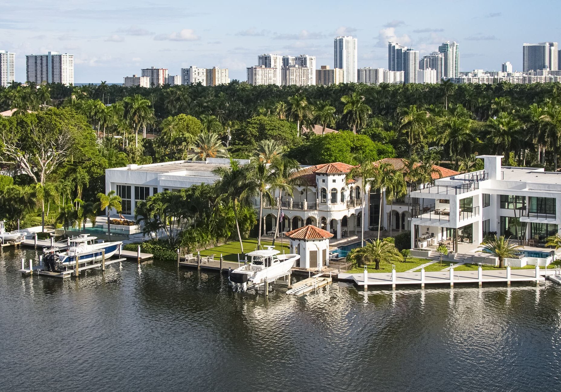 Waterfront mansion amidst tropical trees and skyline by 911 Property Services